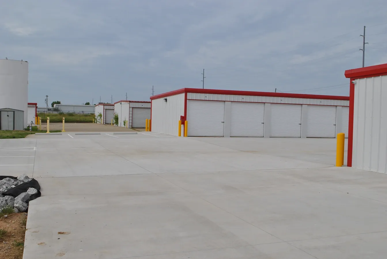 Outdoor storage units with gravel and paved ground.