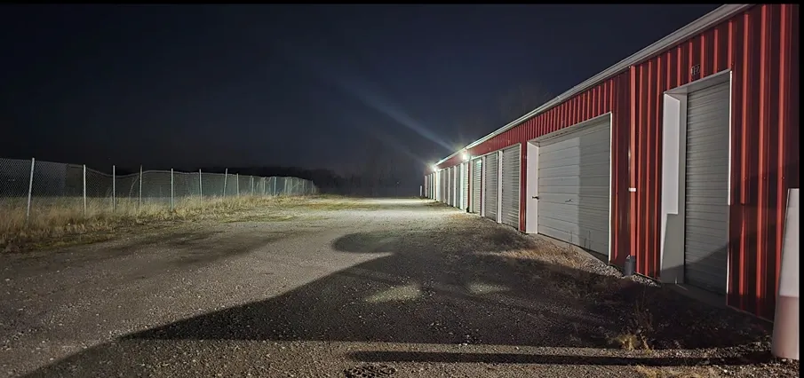Well lit storage units near fence.