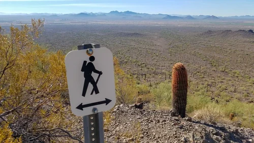 A sign of a person hiking in the Arizona desert at Picacho Peak.