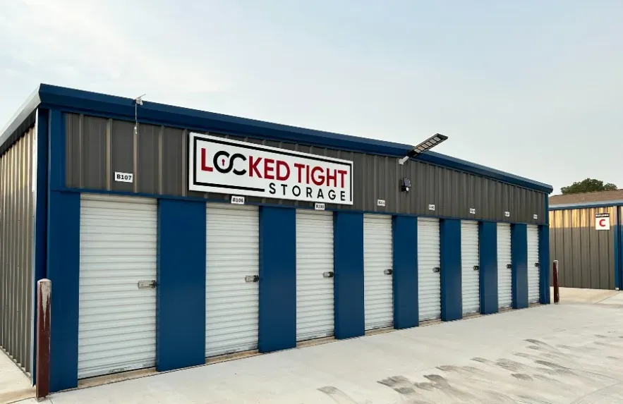 Grey storage facility exterior driveway with Locked Tight Storage sign