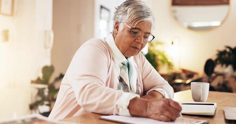 A woman writing out an inventory list as she prepares for self storage.
