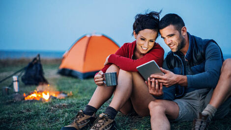 Couple Camping Outside with Fire, Coffee, Tent, and iPad